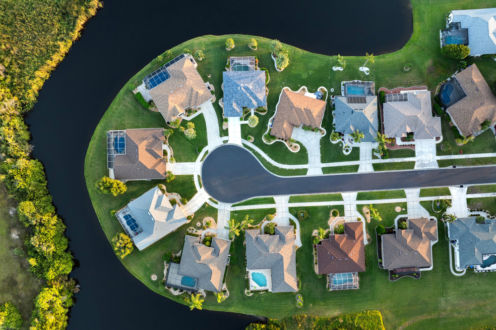 A picture of residential homes with pools in Gainesville, Florida near a retention pond.